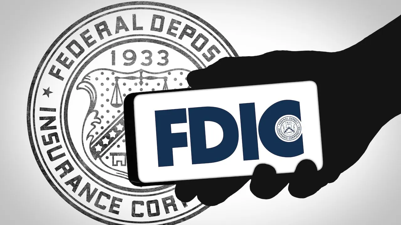 Hand silhouette holding a smartphone that shows the FDIC logo in front of the Federal Deposit Insurance Corporation seal